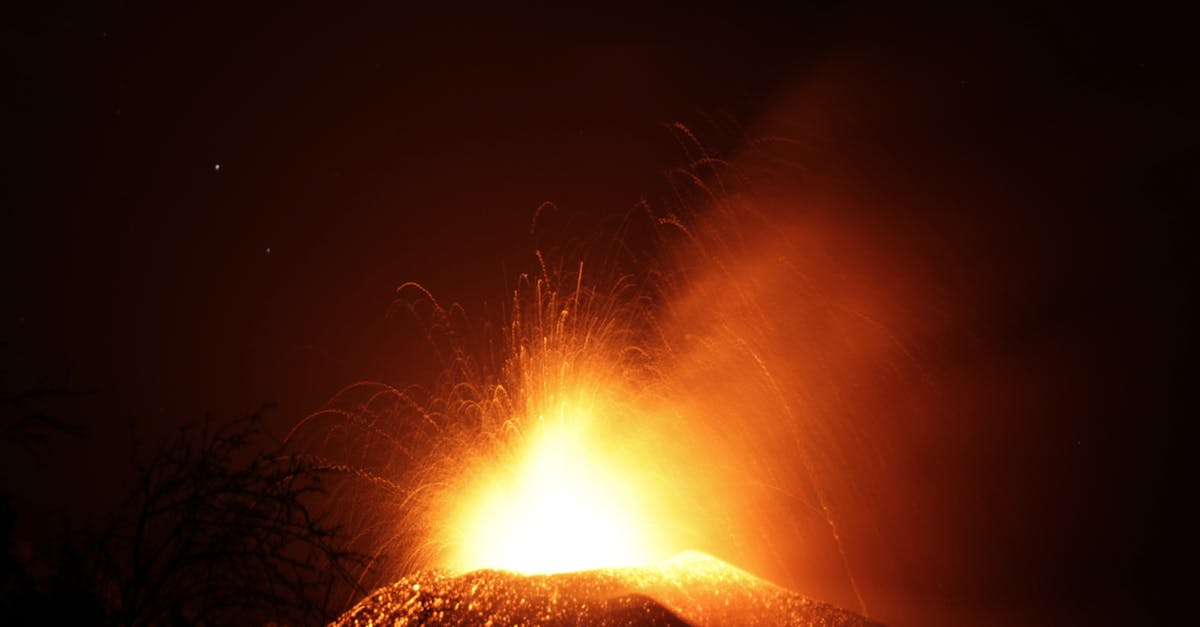 A captivating display of a volcano erupting at night, illuminating the sky with fiery lava and sparks.