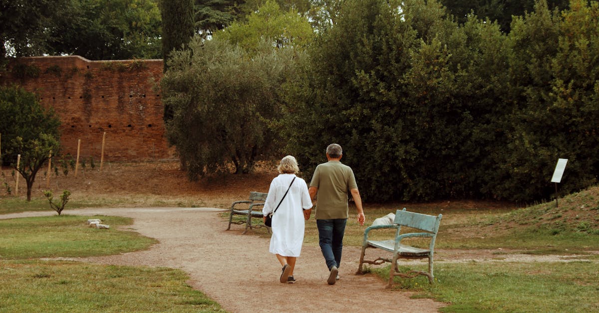 An elderly couple walks through a scenic park in Rome, enjoying a peaceful day.