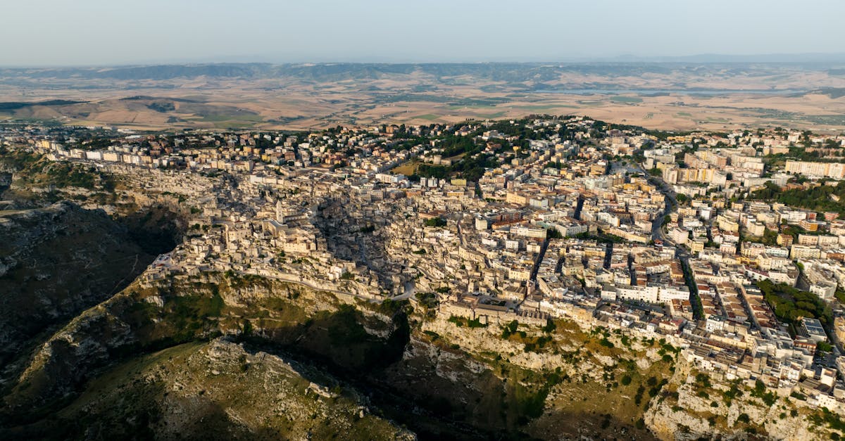 Stunning aerial view of a historic Italian town nestled among cliffs during summer.