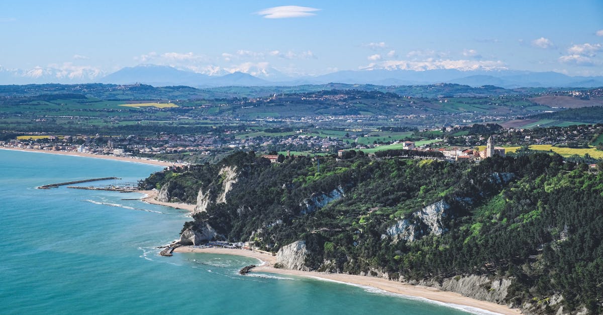 Stunning aerial shot of a coastline with lush greenery and a vibrant blue sea.