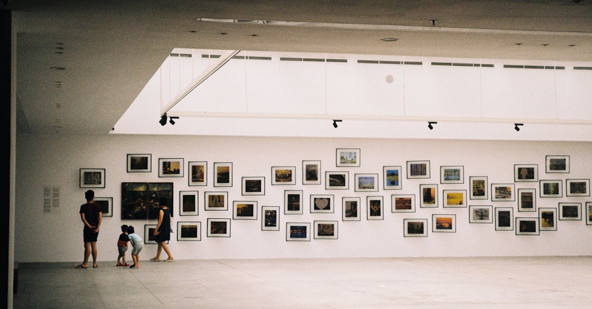 A family exploring an art exhibition in a modern gallery with framed artworks displayed on the wall.