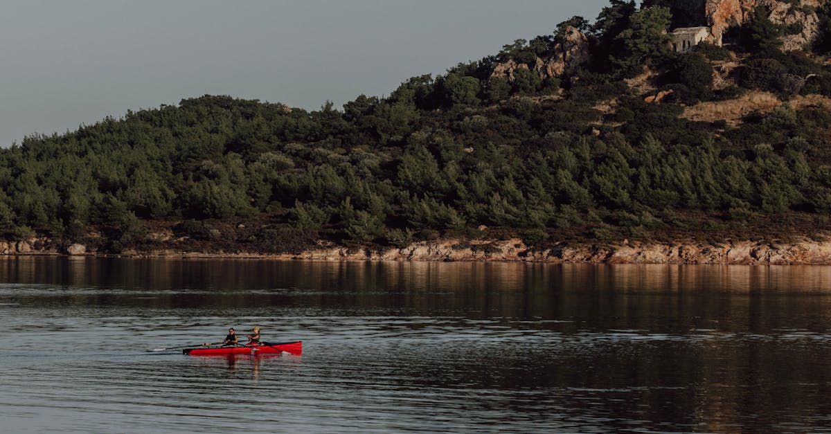 A serene summer day with kayakers paddling across a calm lake in Balıkesir, Türkiye.