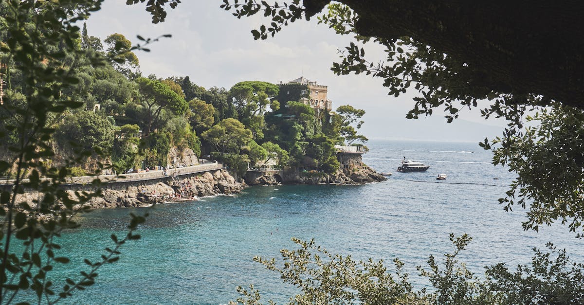 Explore the stunning coastline of Portofino, Italy, featuring lush greenery and the vibrant blue sea.