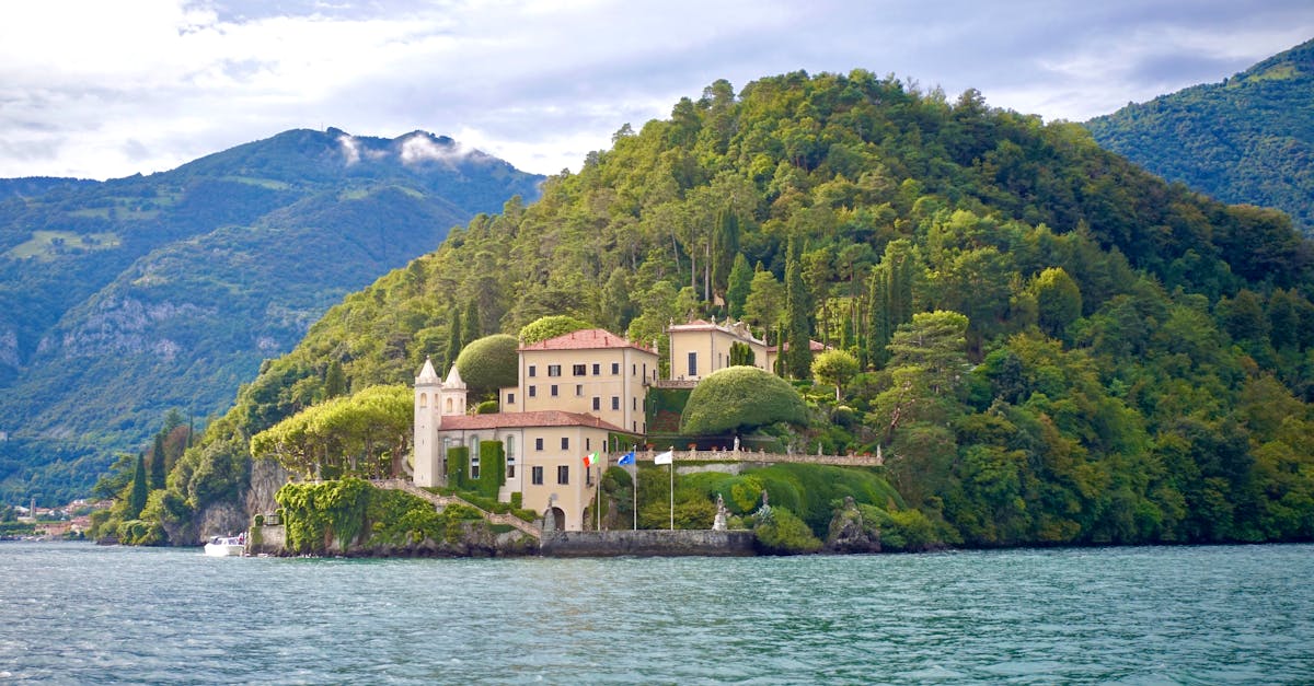 Scenic view of Villa del Balbianello nestled on Lake Como surrounded by lush greenery.