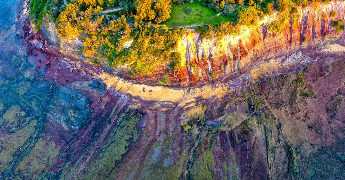 Stunning aerial image showcasing a colorful coastline with vibrant cliffs and lush greenery.