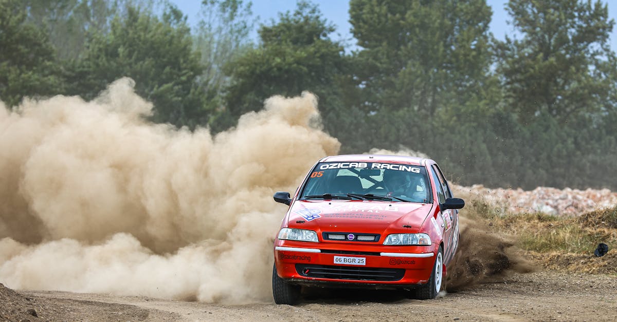 Exciting action shot of a Fiat Palio racing on a dusty track, showcasing speed and control in a rally competition.