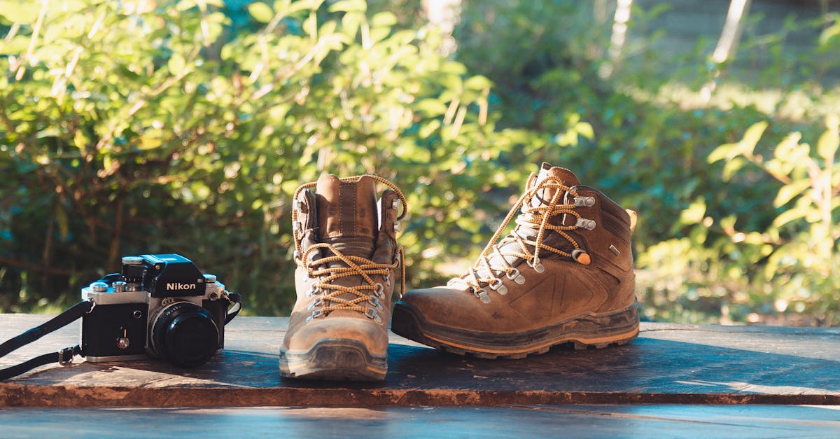 Outdoor hiking scene with boots and camera on a wooden surface, perfect for adventure themes.