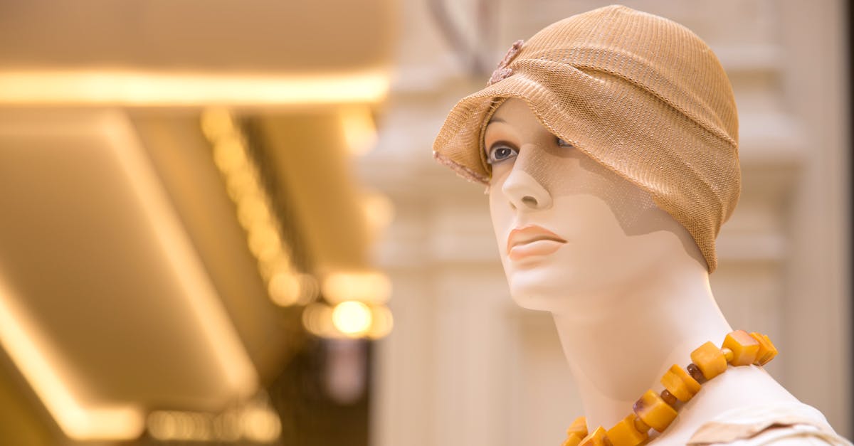 Mannequin display in a fashion store with a stylish hat and necklace.