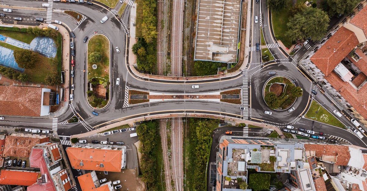 Aerial cityscape of Alba, Italy showcasing overpasses, roads, and railway tracks.