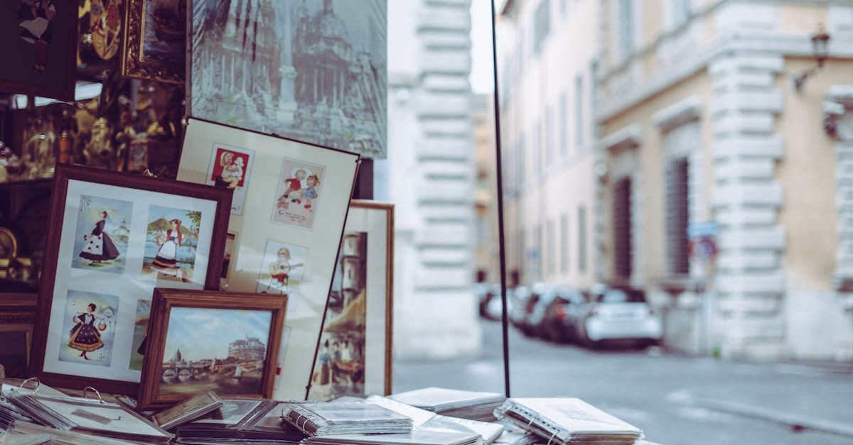 Framed art and pictures displayed at a street market in Rome, capturing the city's vibrant outdoor shopping scene.