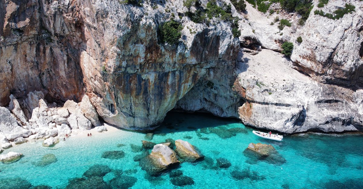 A breathtaking aerial shot of a rocky cove with turquoise water and a small beach, perfect for relaxation.