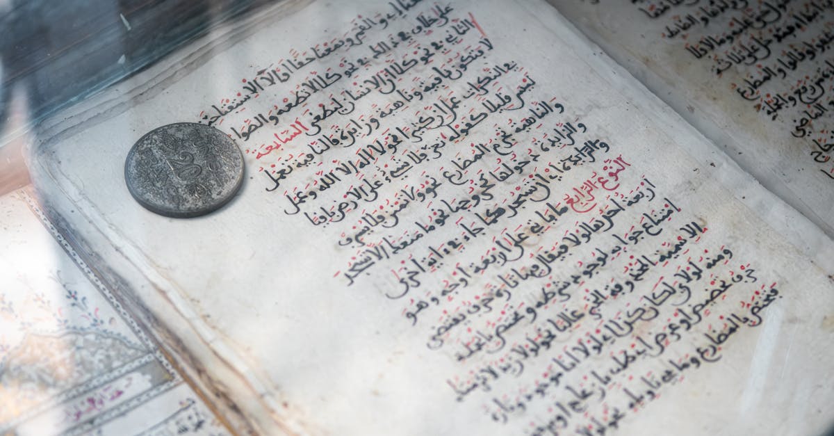 Detailed view of an ancient Arabic manuscript and old coin on display, showcasing Islamic calligraphy.