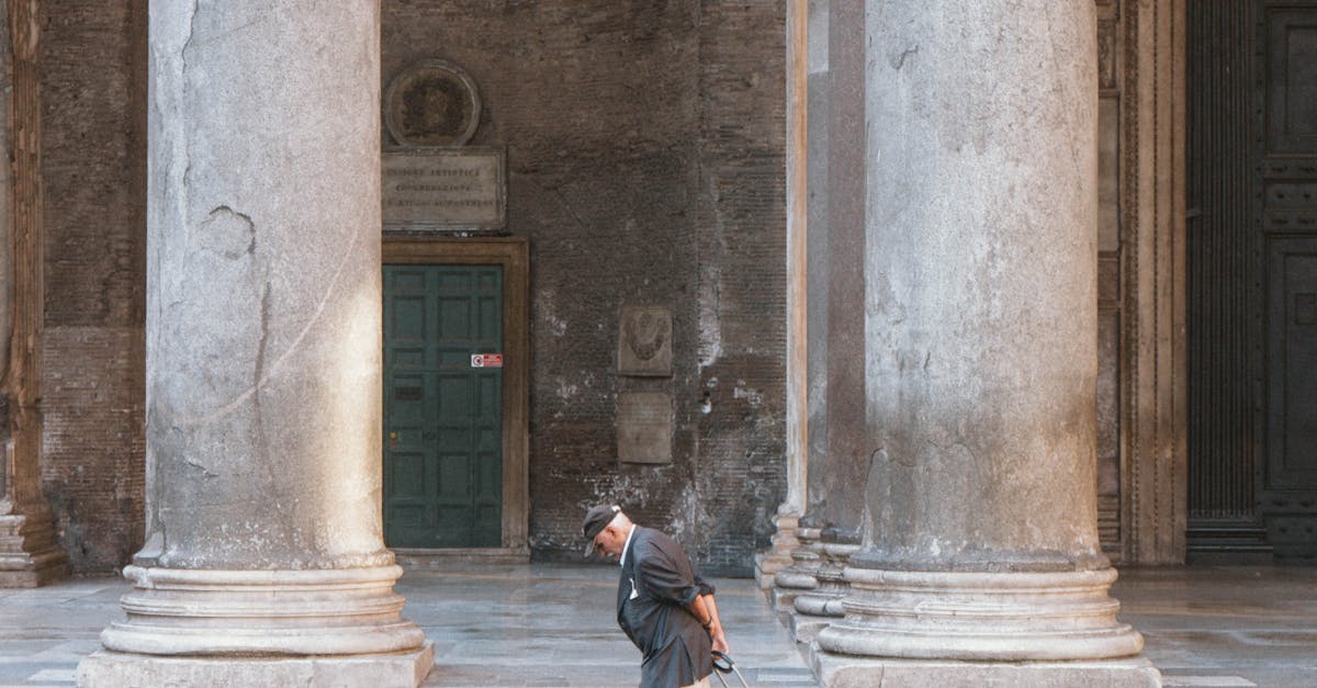Elderly man with suitcase walking past large columns in Rome. Urban scene in Italy.