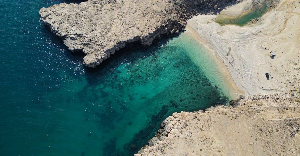 Explore the hidden beauty of Dhofar, Oman with this breathtaking aerial shot of a secluded beach cove.