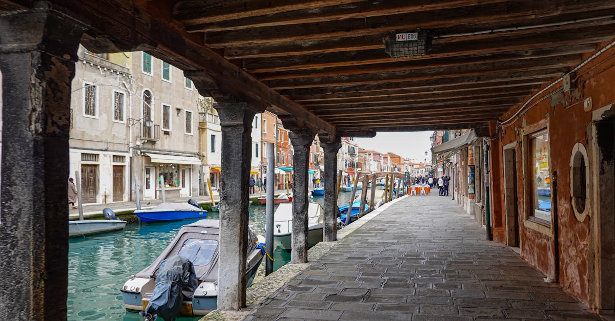 Picturesque view of a canal in Murano, Italy, with rustic buildings and boats lining the waterway.