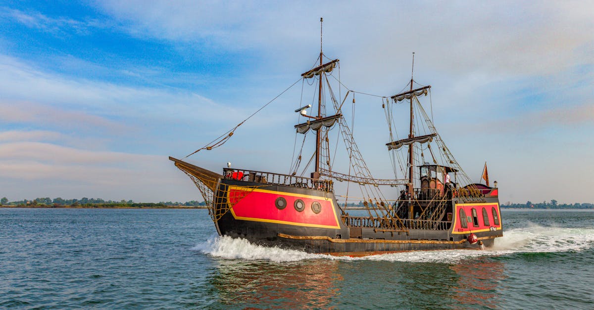 A vibrant pirate ship sails on a clear day, showcasing its vintage wooden structure and colorful design.