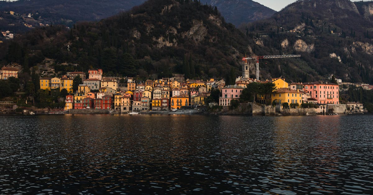 Charming Italian town on Lake Como with colorful houses at dusk, surrounded by mountains.