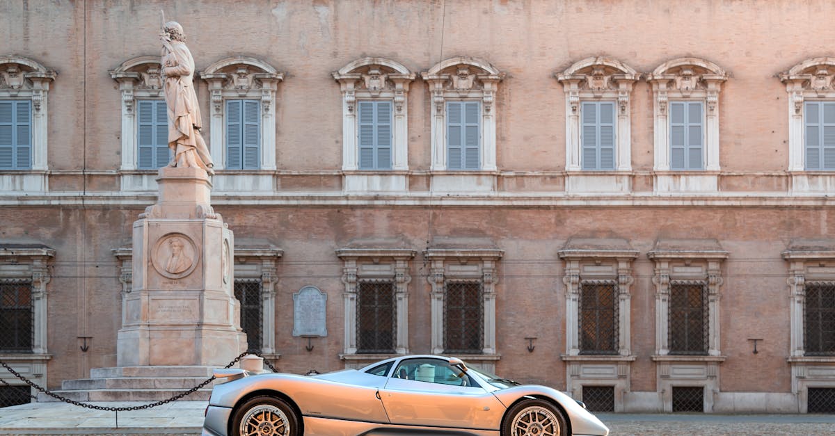 Silver sports car parked in a historic Italian courtyard with classical architecture.