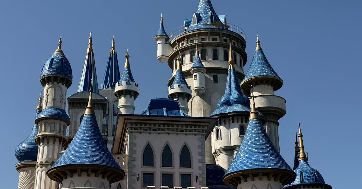Fantasy castle with blue turrets under a clear sky, evoking fairy tale magic.