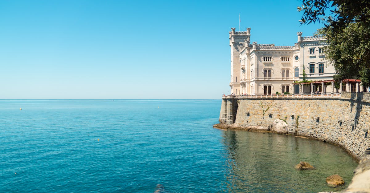 Miramare Castle overlooking the serene Adriatic Sea on a sunny day in Grignano, Italy.