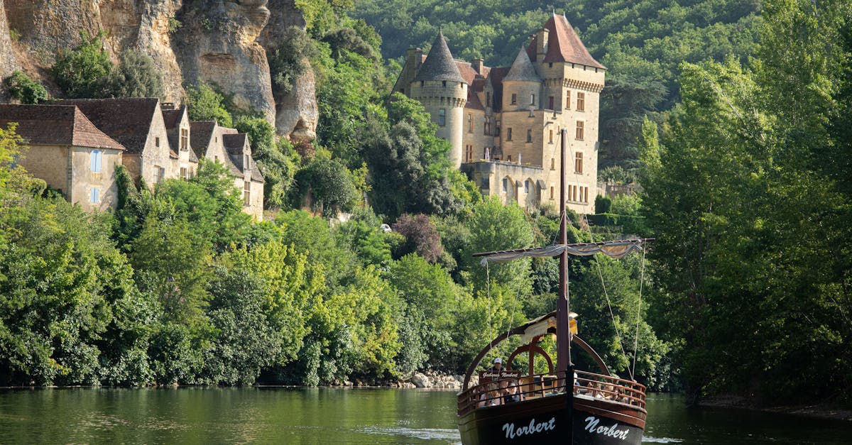 Charming boat on Dordogne River near a medieval castle in Nouvelle-Aquitaine, France.