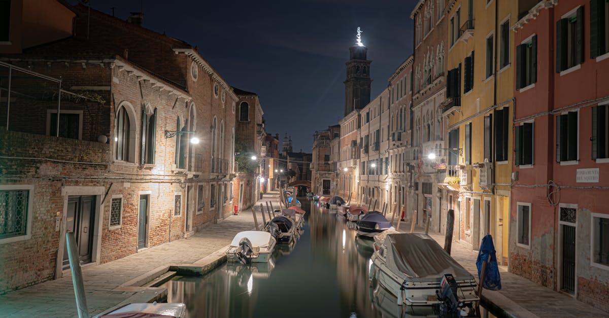 Serene Venetian canal at night showcasing beautiful architecture and reflections.
