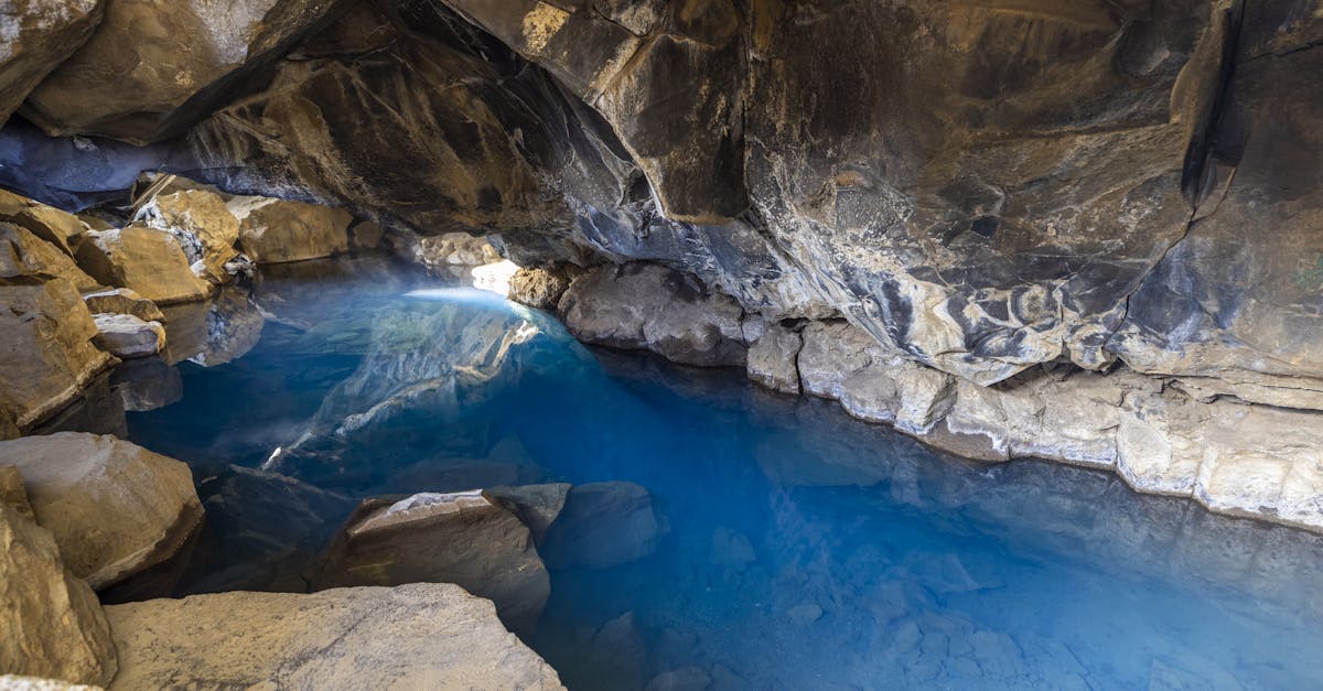 Explore the serene blue waters and rugged rock formations of a mysterious cave.