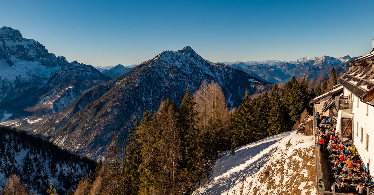 Breathtaking view of the Italian Alps with a busy dining terrace overlooking snow-capped mountains.