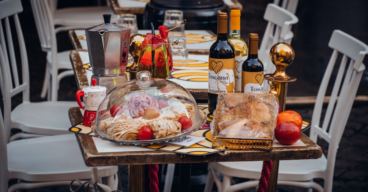 Close-up of a dining table set outdoors with Italian cuisine, featuring wine, coffee pot, and pastries.