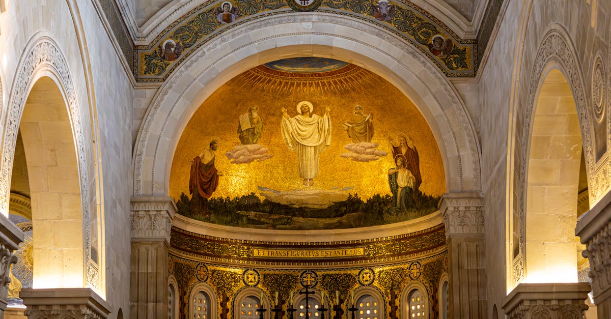 A stunning church interior featuring an intricate religious mosaic under a grand archway.