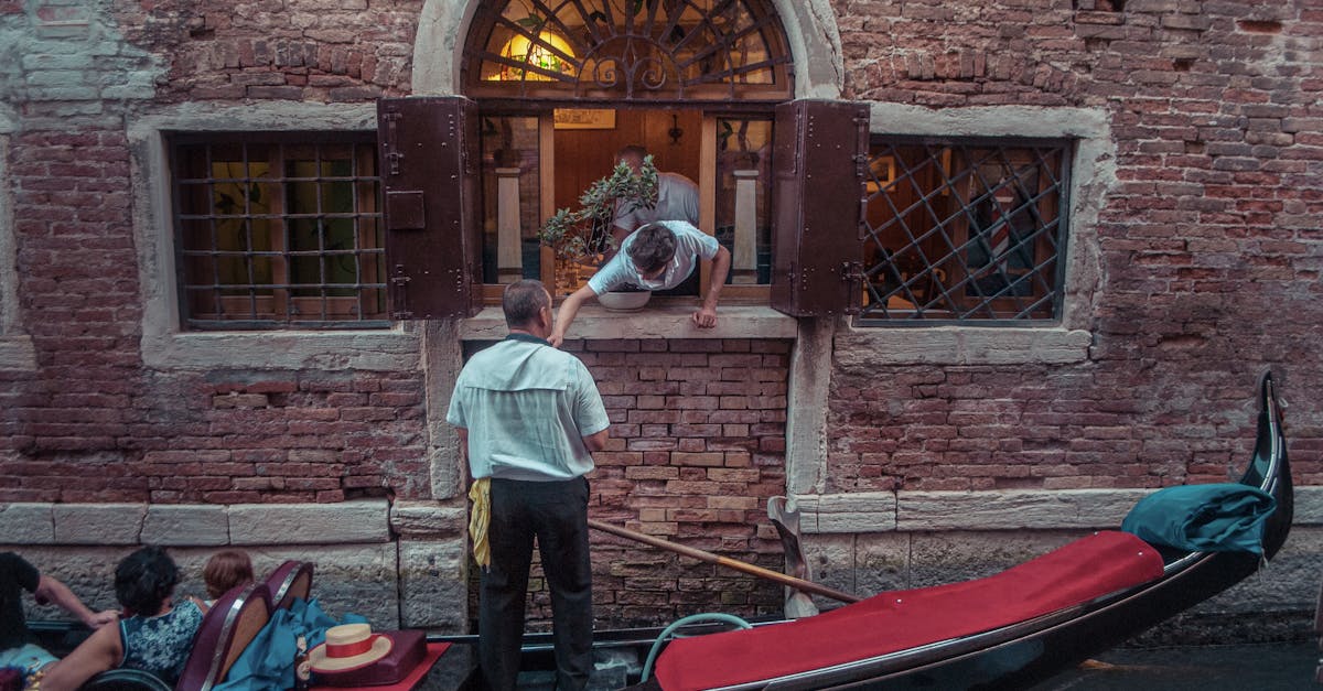 A gondola gently floating by a brick building in Venice, capturing an authentic Venetian exchange.