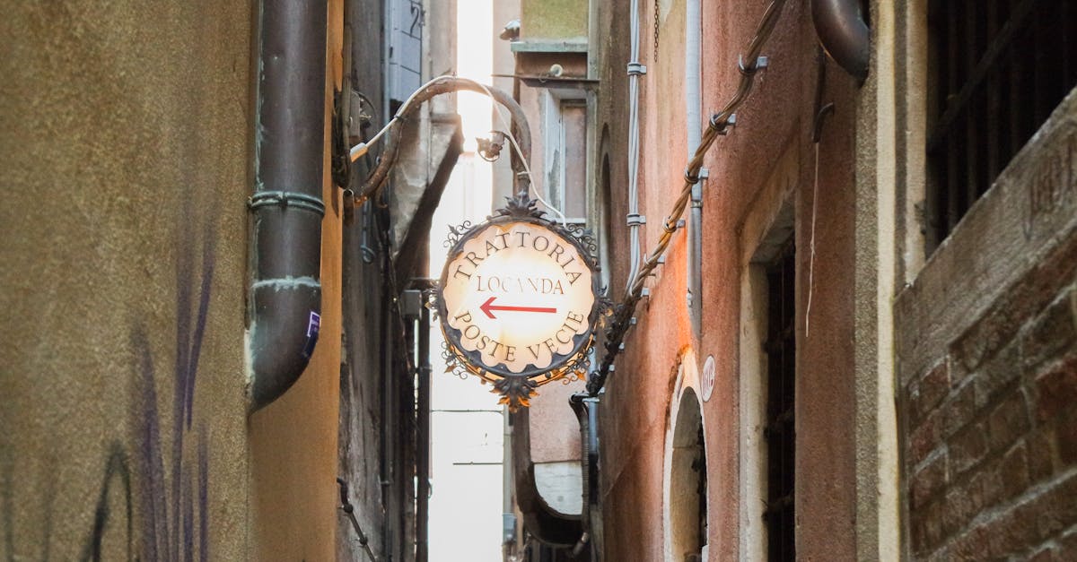 Narrow alleyway leading to Trattoria Locanda Poste Vecie in Venice, Italy, showcasing classic Italian architecture.