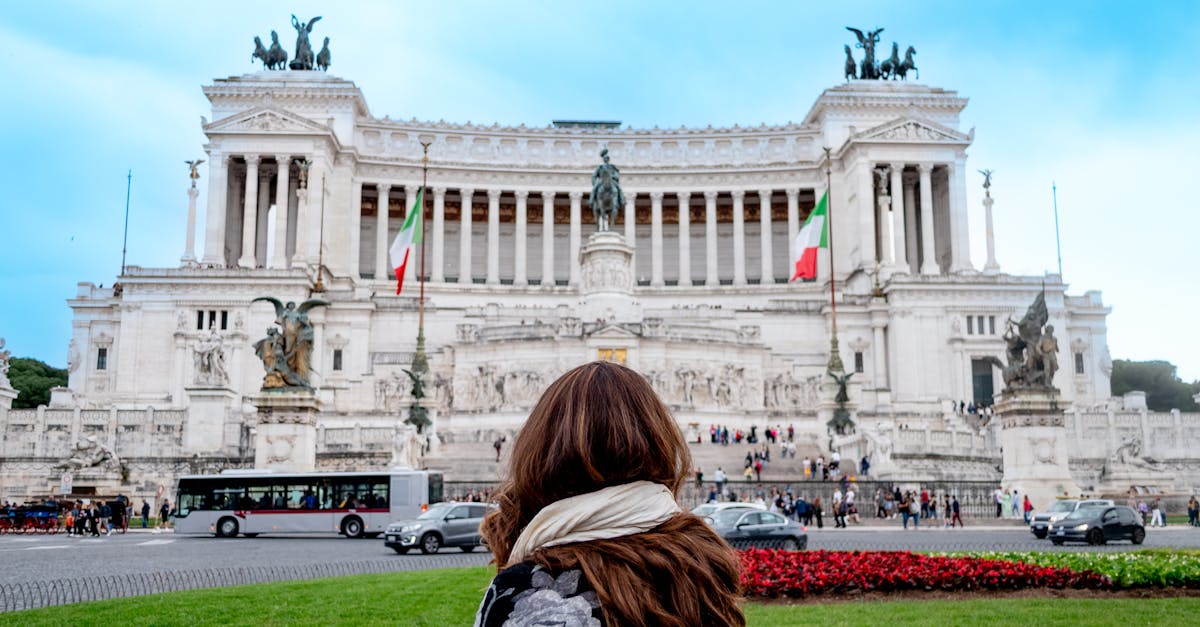 A woman stands before the iconic Il Vittoriano in Rome, Italy, capturing its grandeur.