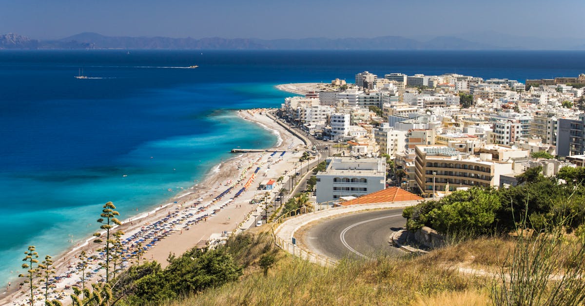 Stunning aerial view of Rhodes, Greece with its beautiful beach and vibrant cityscape under a clear blue sky.