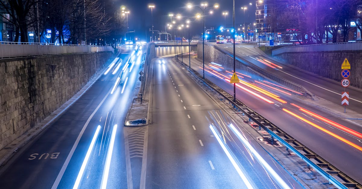 Long exposure photo capturing light trails of traffic on a busy Warsaw highway at night.