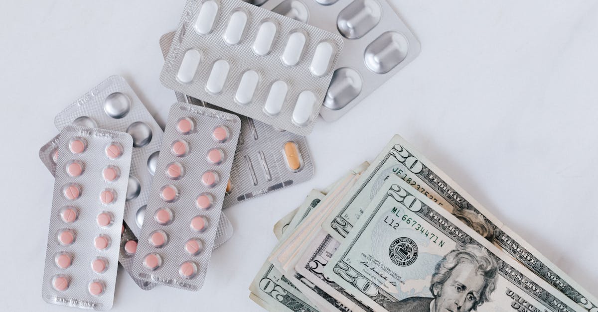 Top view of different blisters of medications and pills composed with heap of paper money