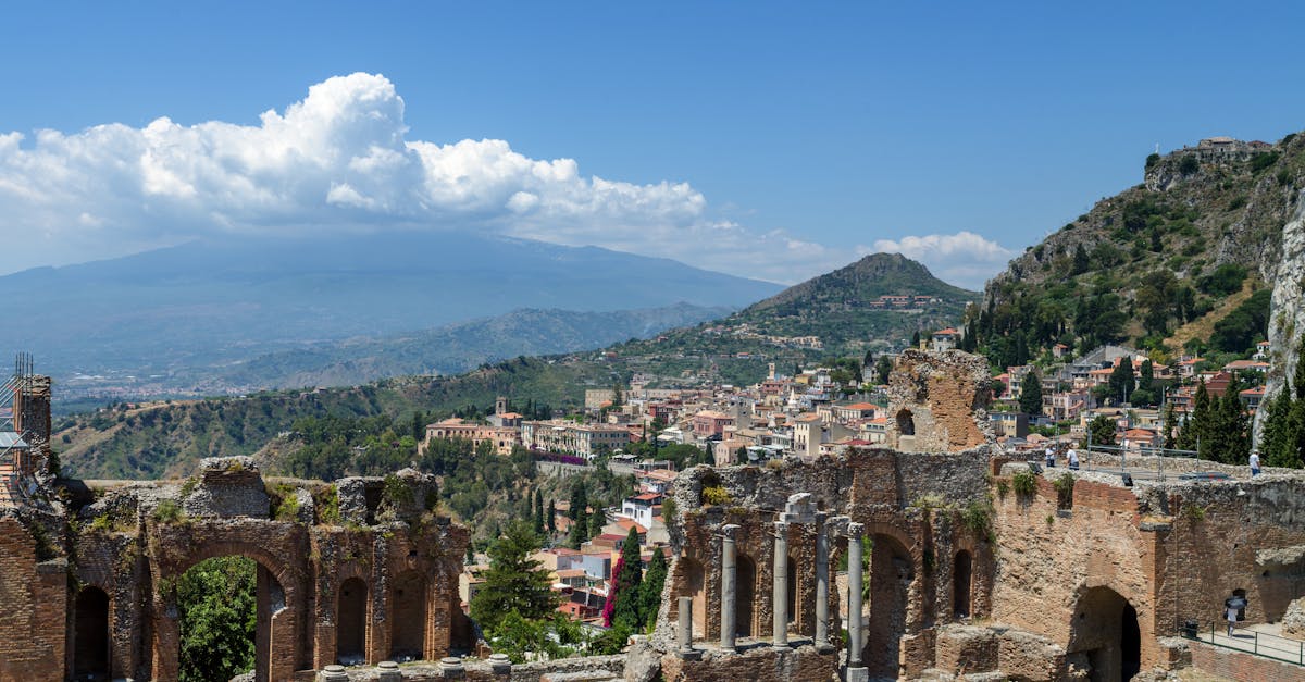 Explore the awe-inspiring ruins of the Ancient Theatre of Taormina, Sicily with Mount Etna in the background.