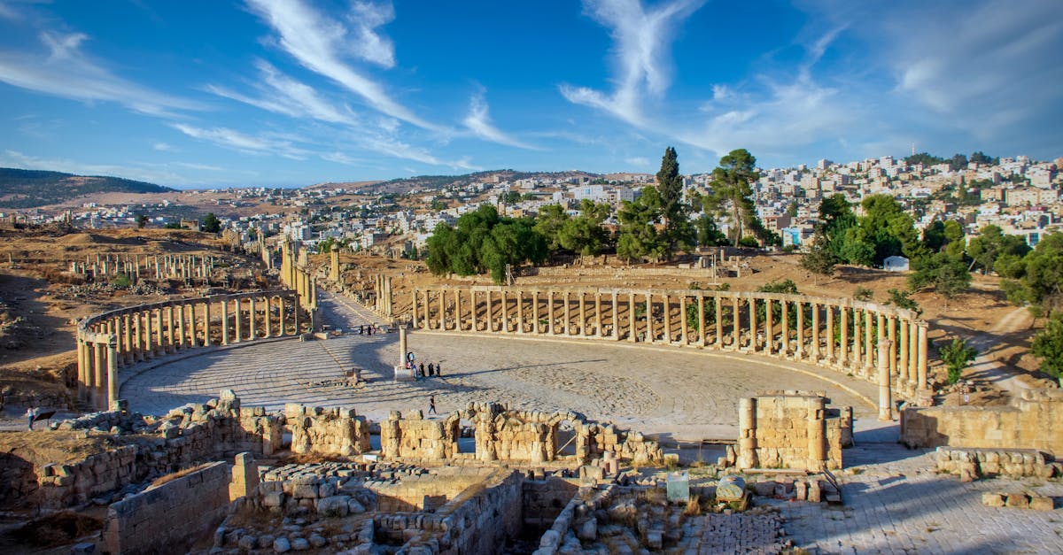 Explore the ancient Roman ruins of Jerash, Jordan, with stunning architectural details under a vibrant blue sky.