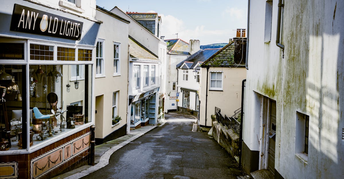 A picturesque narrow street lined with quaint shops in a coastal UK town.
