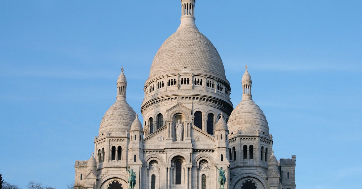 A scenic view of the iconic Sacre Coeur Basilica in Paris, highlighting its architectural beauty against a clear blue sky.