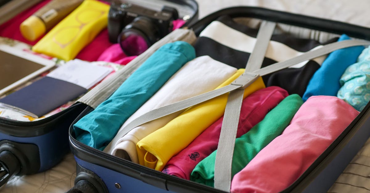 Open suitcase neatly packed with colorful clothes and travel essentials.