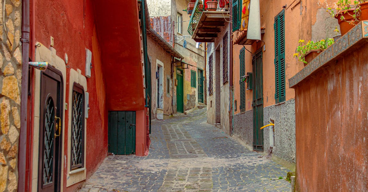 Explore a picturesque cobblestone alleyway in Italy with vibrant old world architecture.