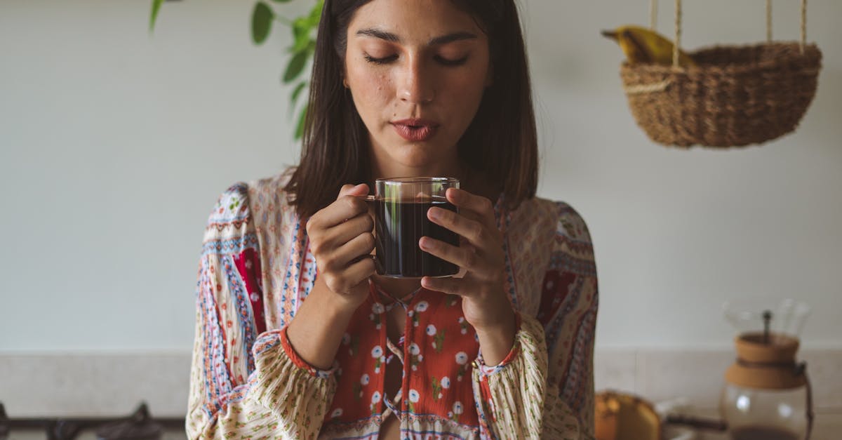 A woman enjoying a hot cup of coffee in a cozy kitchen environment, surrounded by natural elements.