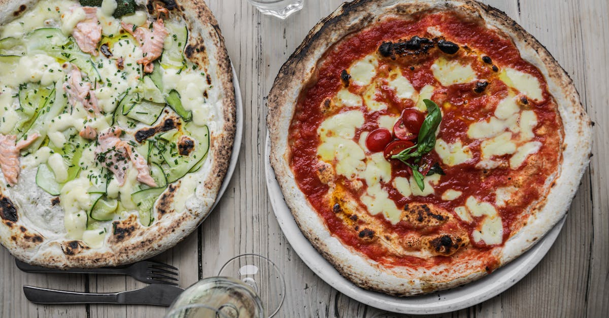 Two gourmet pizzas with unique toppings: salmon with zucchini and classic margherita.