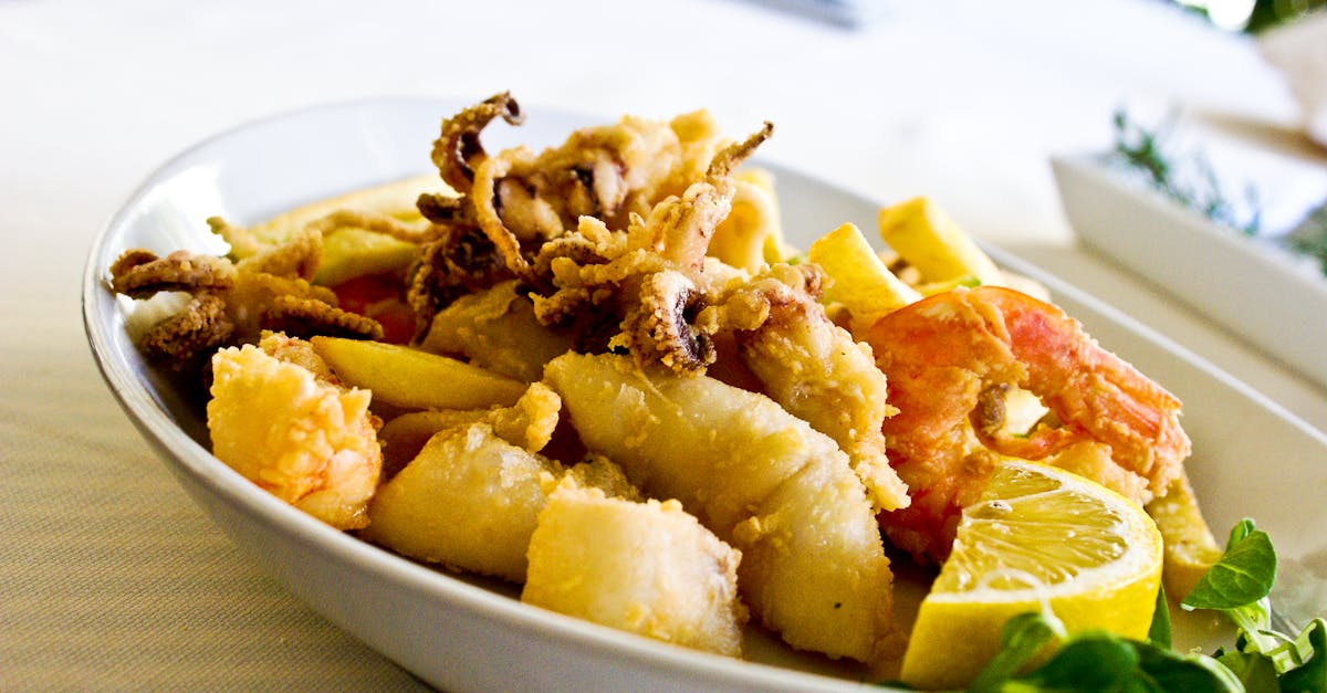 Delicious seafood platter featuring fried shrimp and squid garnished with lemon and greens.