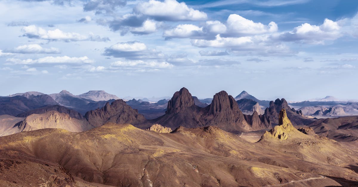 A breathtaking view of a mountain range under a vivid blue sky with scattered clouds.
