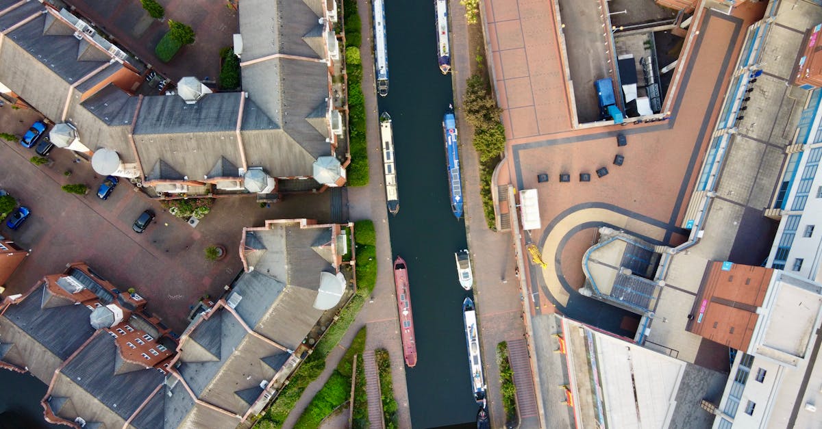 Top view of boats navigating a city canal surrounded by modern buildings.